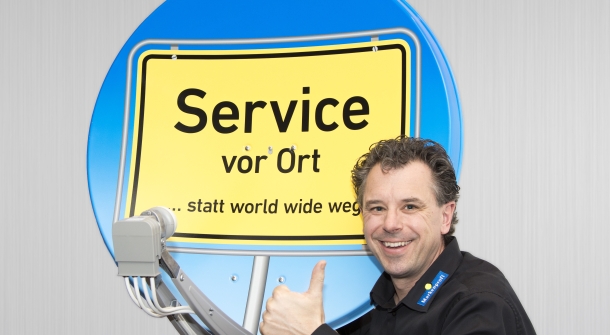 Herr Schindel posiert vor einem Satelliten.