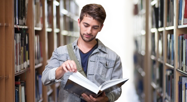 Eine Person liest ein Buch in der Bücherei.
