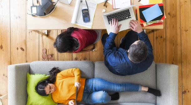 Zwei Personen mit Laptop und Büroartikeln auf einem Schreibtisch.