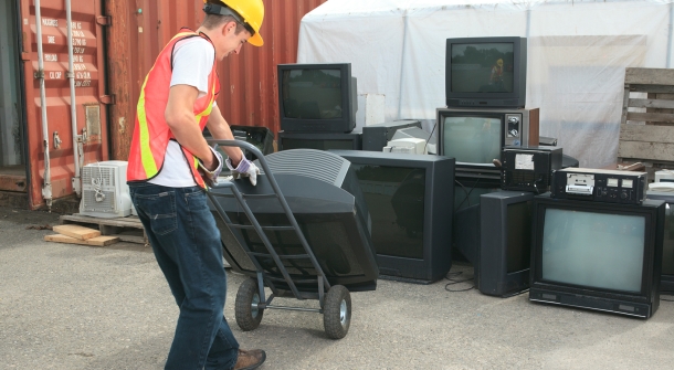 Eine Person die Fernseher entsorgt.